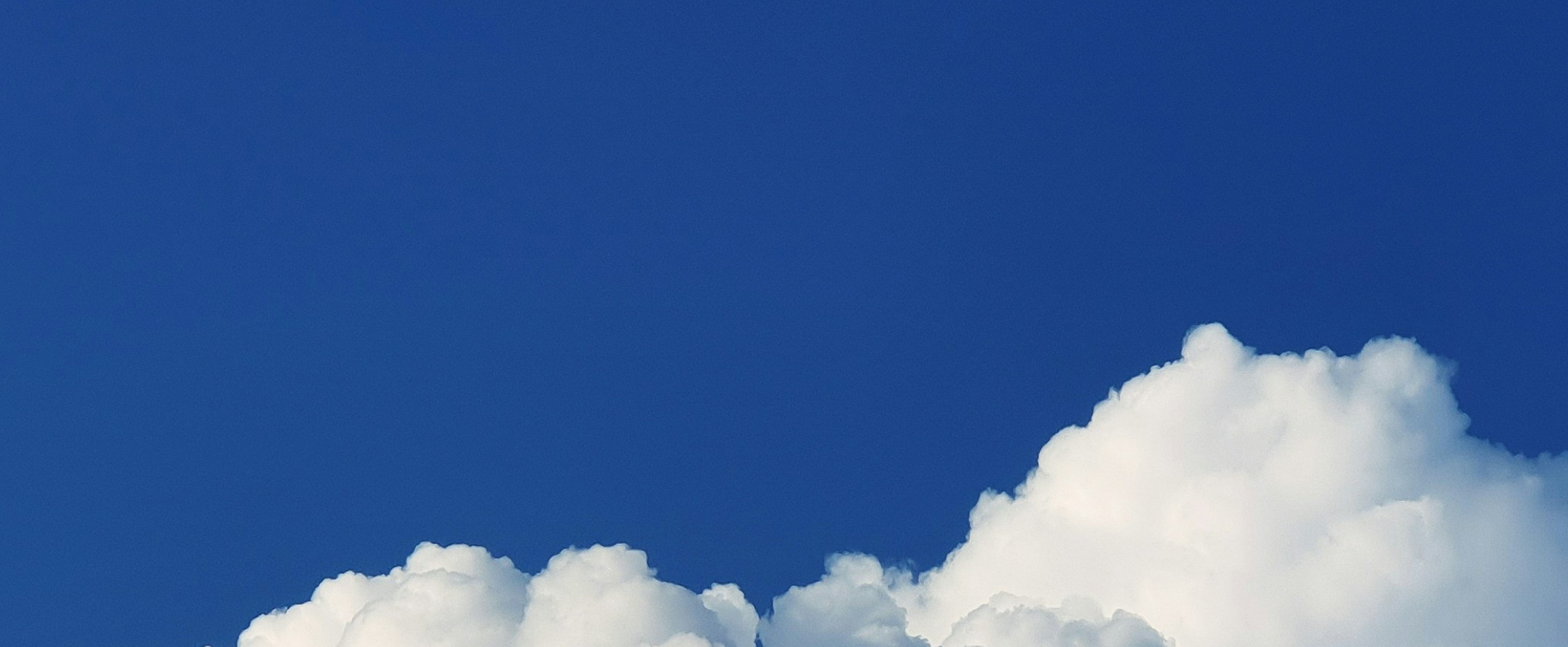 A cut-out part of the cloud at the bottom of the photo covers a small part of the blue sky.